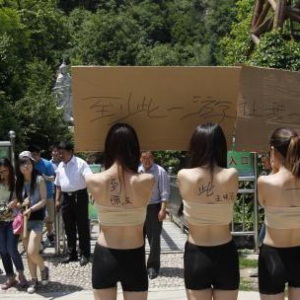 景区女子脱外衣举牌邀游客签名“到此一游”